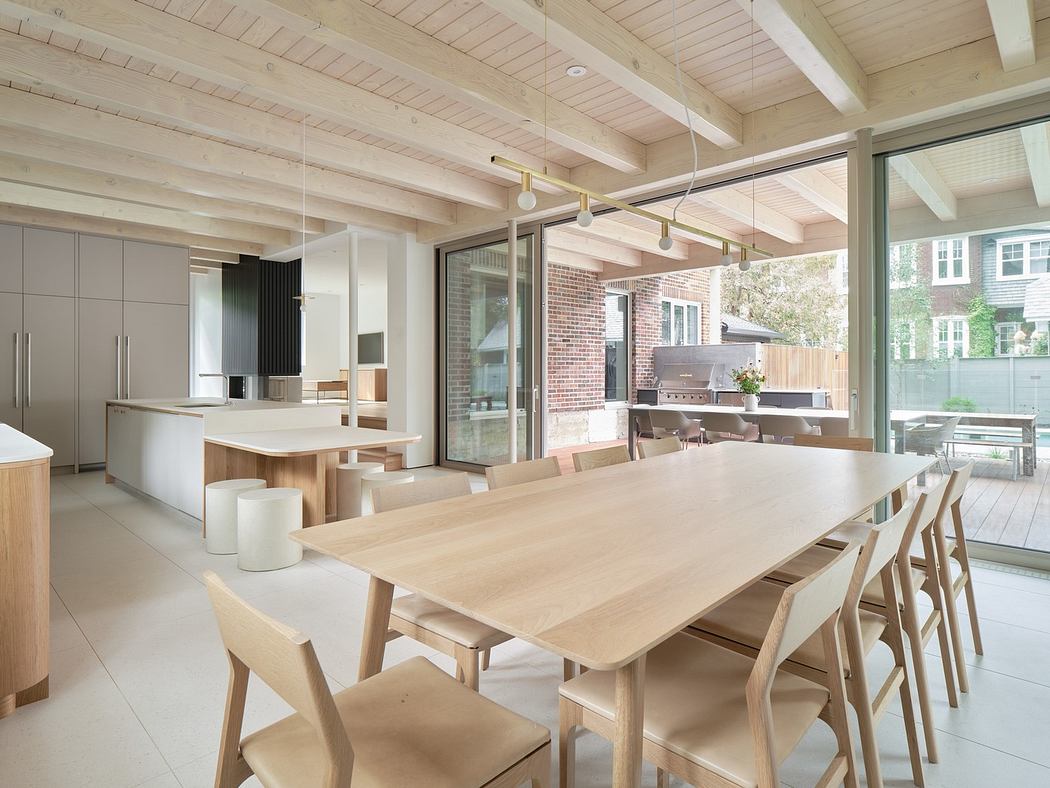 Modern kitchen with wooden table, chairs, and exposed ceiling beams.