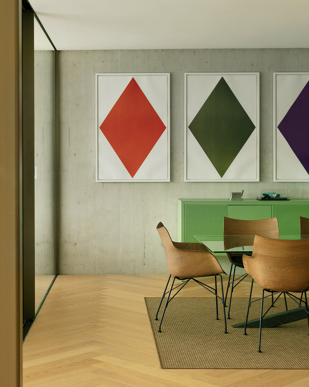 Modern room with concrete wall, geometric art, and wooden furniture.