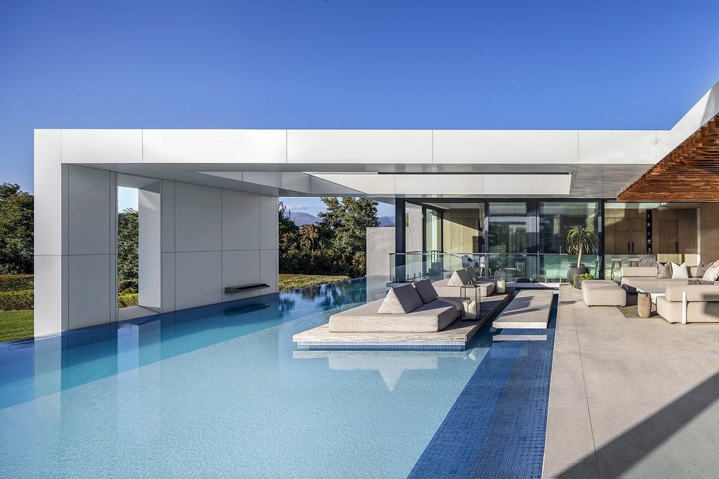 Modern house with large pool, glass walls, and minimalist design.
