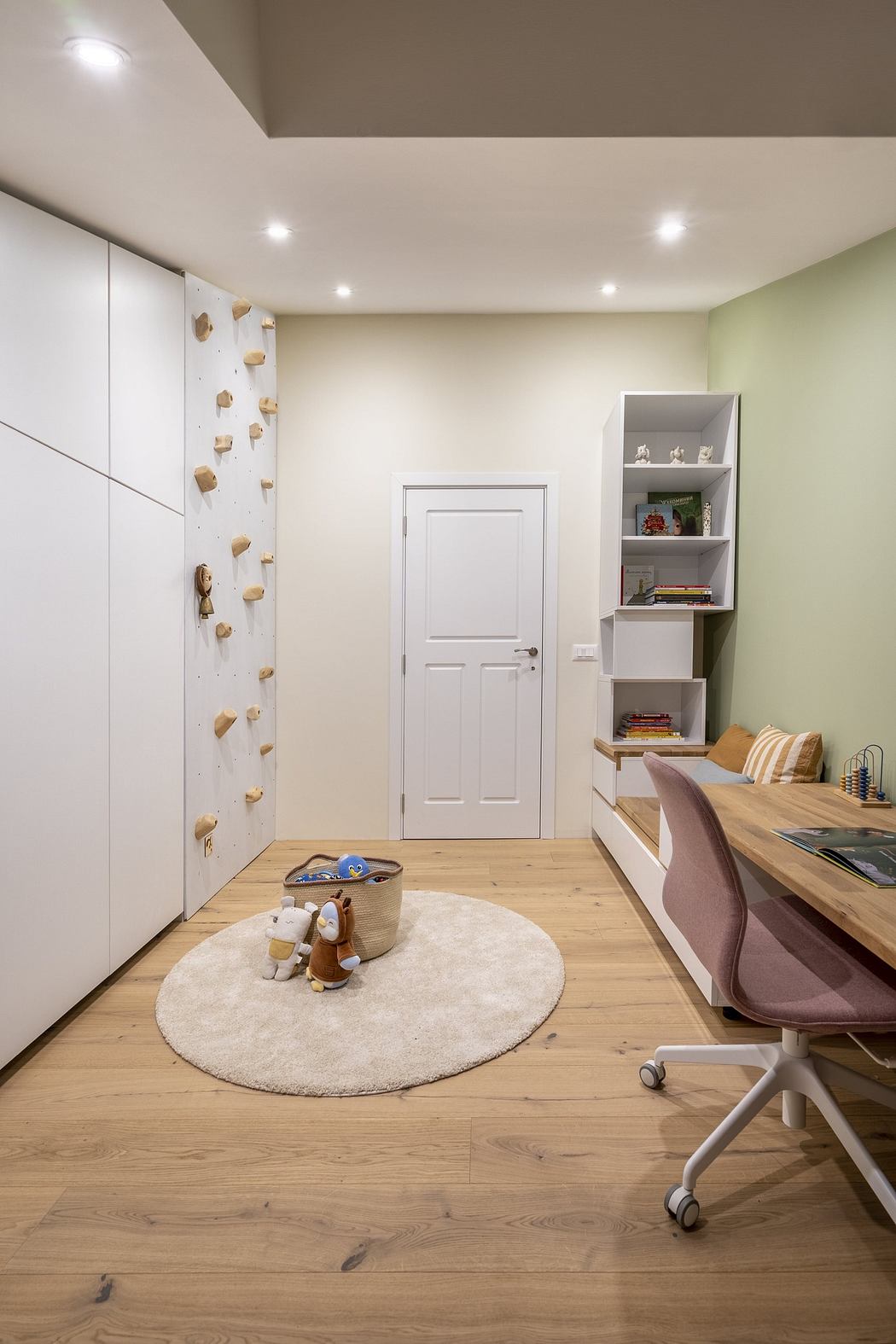 Modern home office with a wooden desk, white cabinetry, and decorative wall elements
