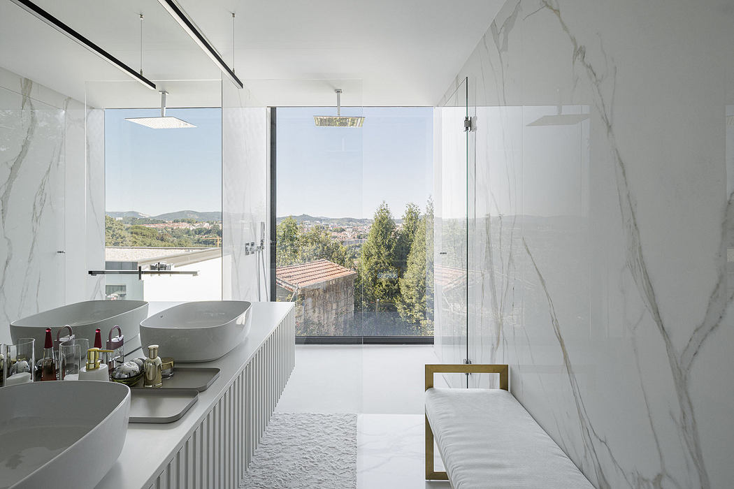 Modern bathroom with marble walls, freestanding tub, and scenic view.