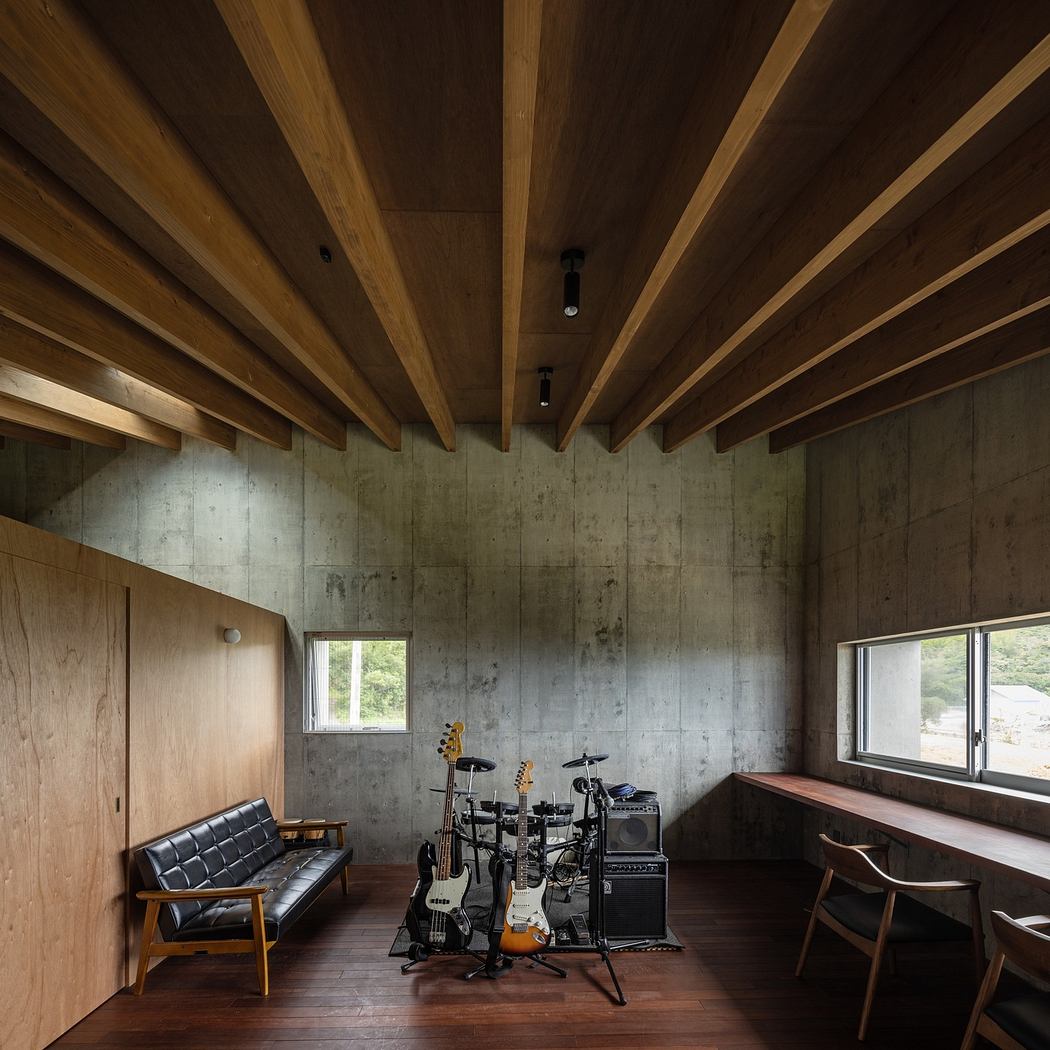 Modern room with wooden ceiling beams, concrete walls, and musical instruments.