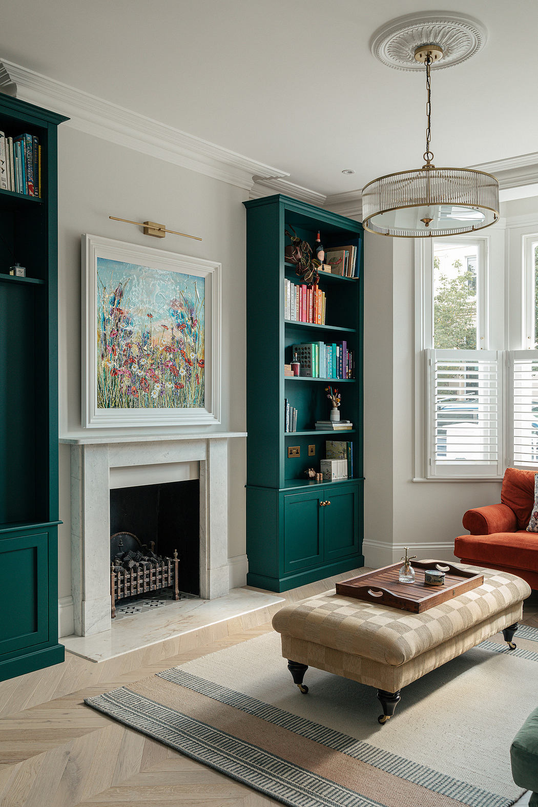 Elegant living room with teal bookcases, a fireplace, and a chandelier