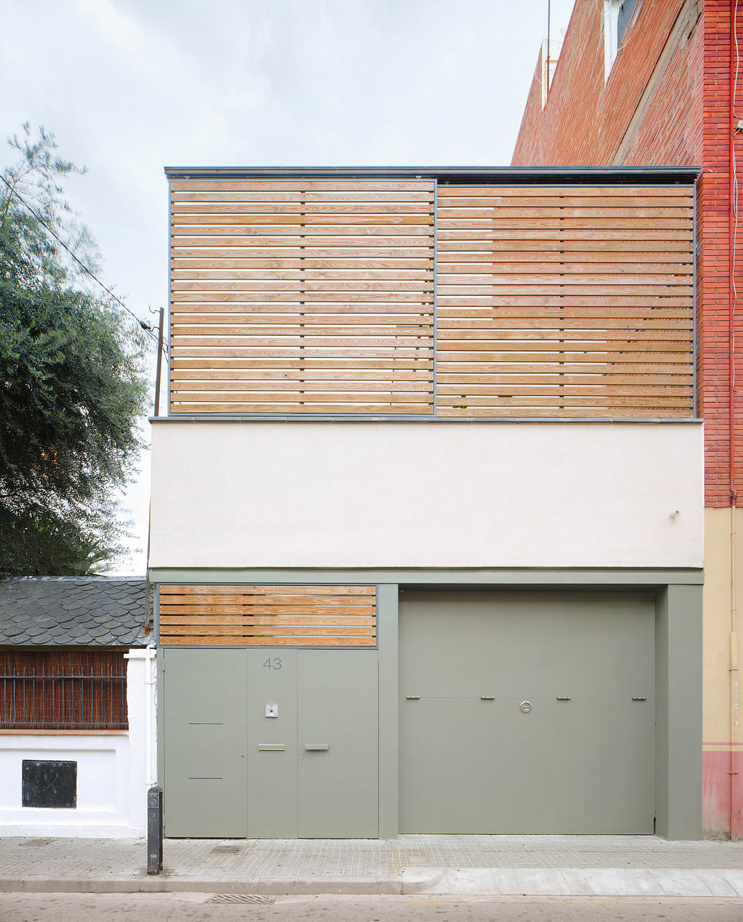Modern two-story building facade with wooden slat upper level and gray garage.