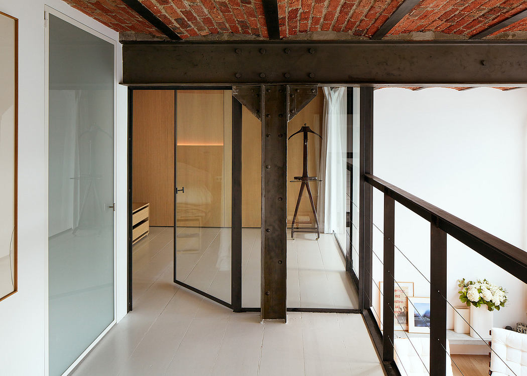Modern interior with exposed beams, glass partitions, and white walls.