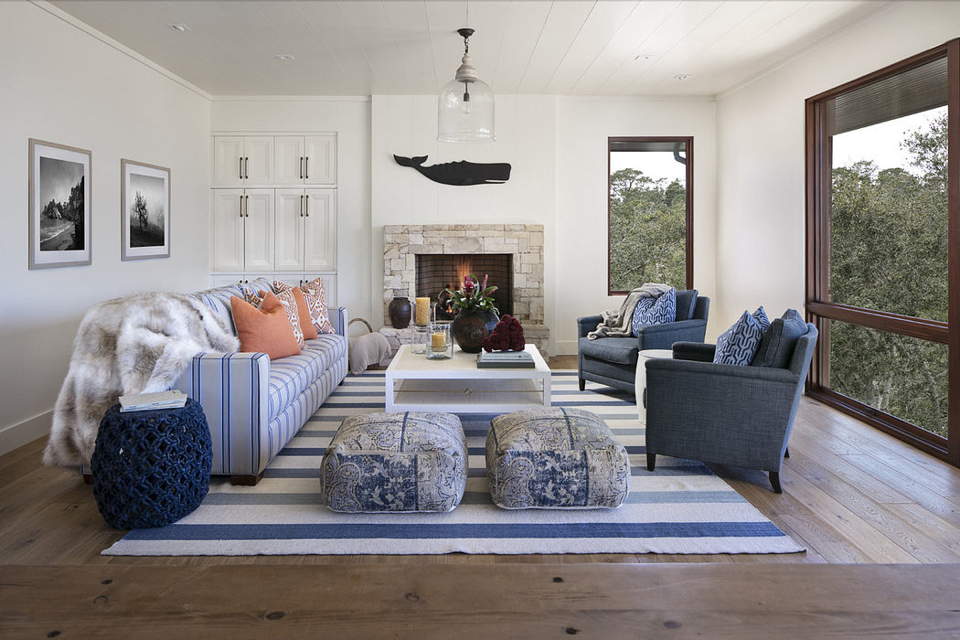 Elegant living room with fireplace, striped rug, and cozy seating.