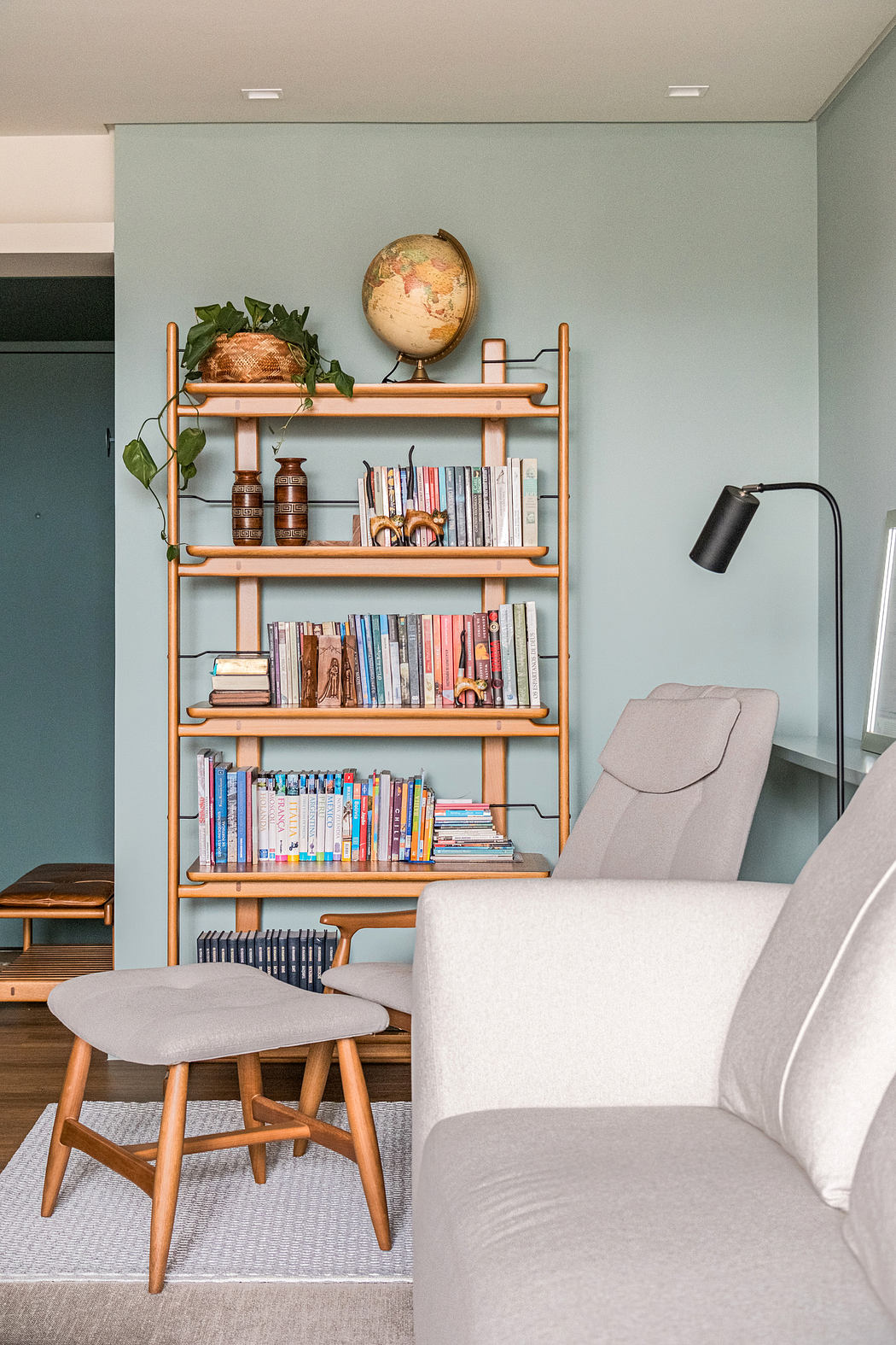 Modern living room corner with bookshelf, chair, and stylish decor.