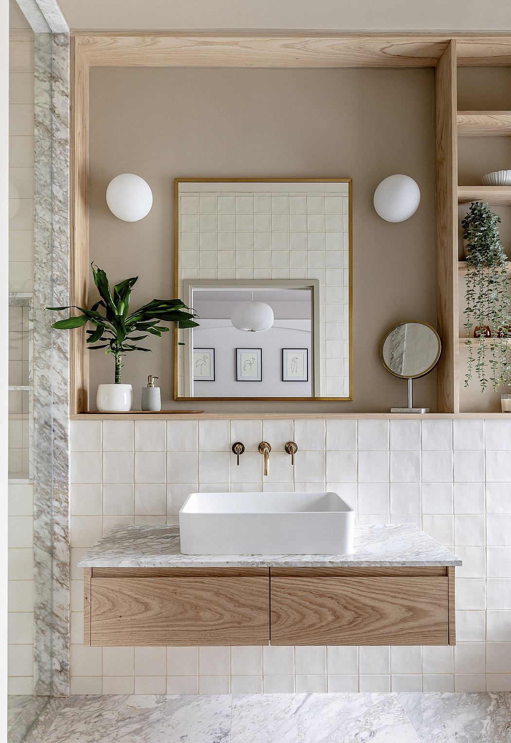 Elegant bathroom with wooden vanity, white basin, brass taps, and framed mirror