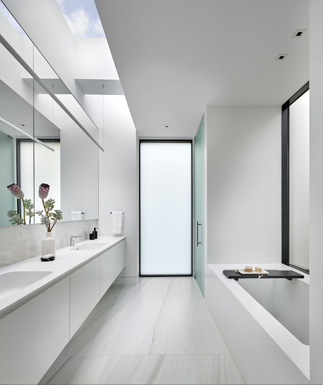 Modern bathroom with white minimalist design and sleek fixtures.