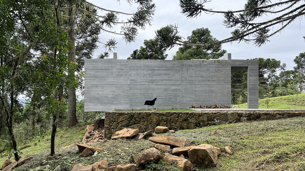 Modern minimalist structure in a forest setting with large opening and hammock.