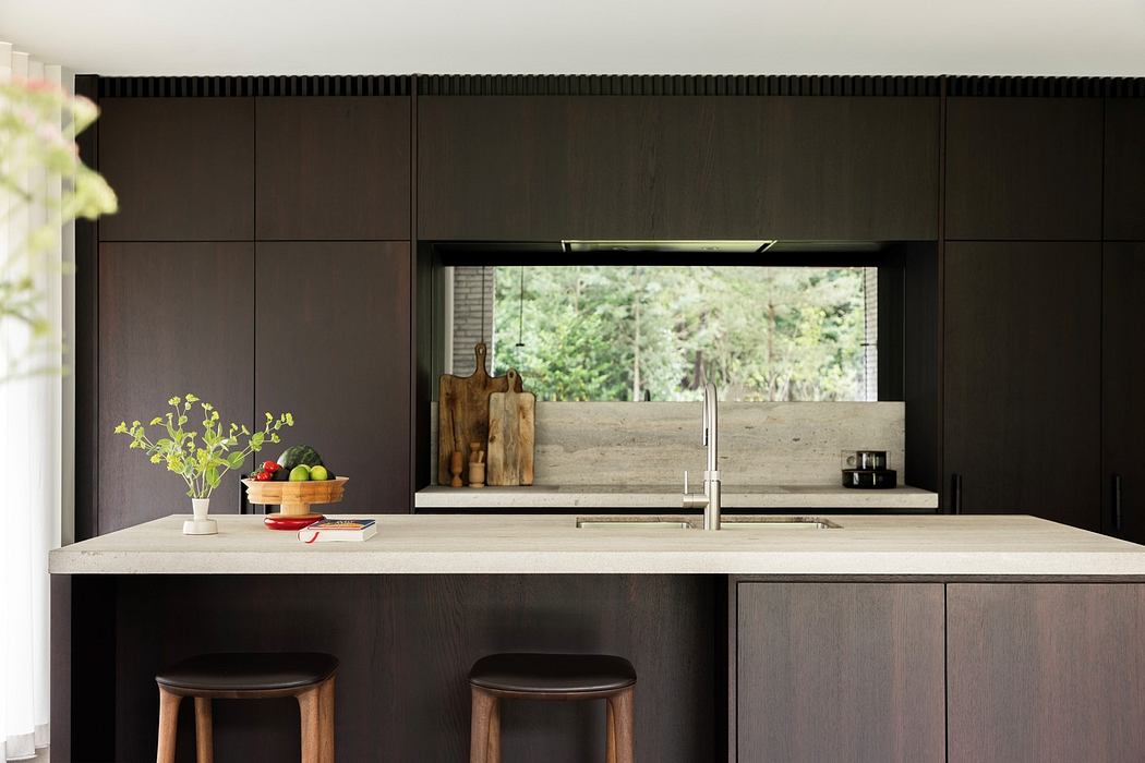 Modern kitchen with dark cabinetry, island counter, and bar stools.