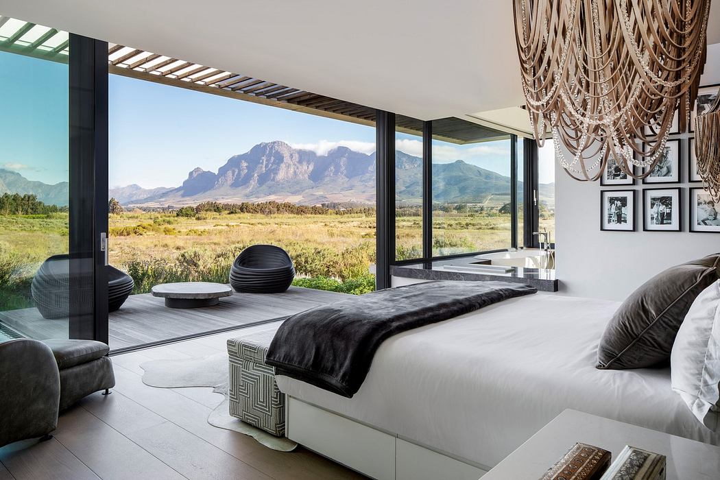 Modern bedroom with large windows overlooking mountains.