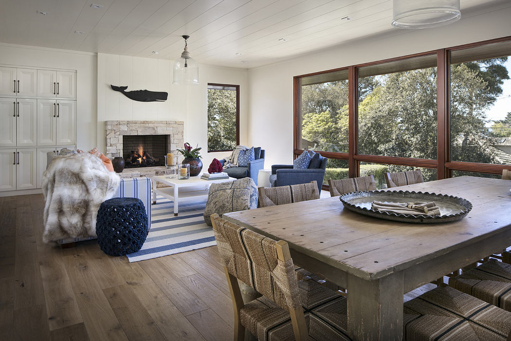 Bright, cozy living room with fireplace, large windows, and wooden furniture.