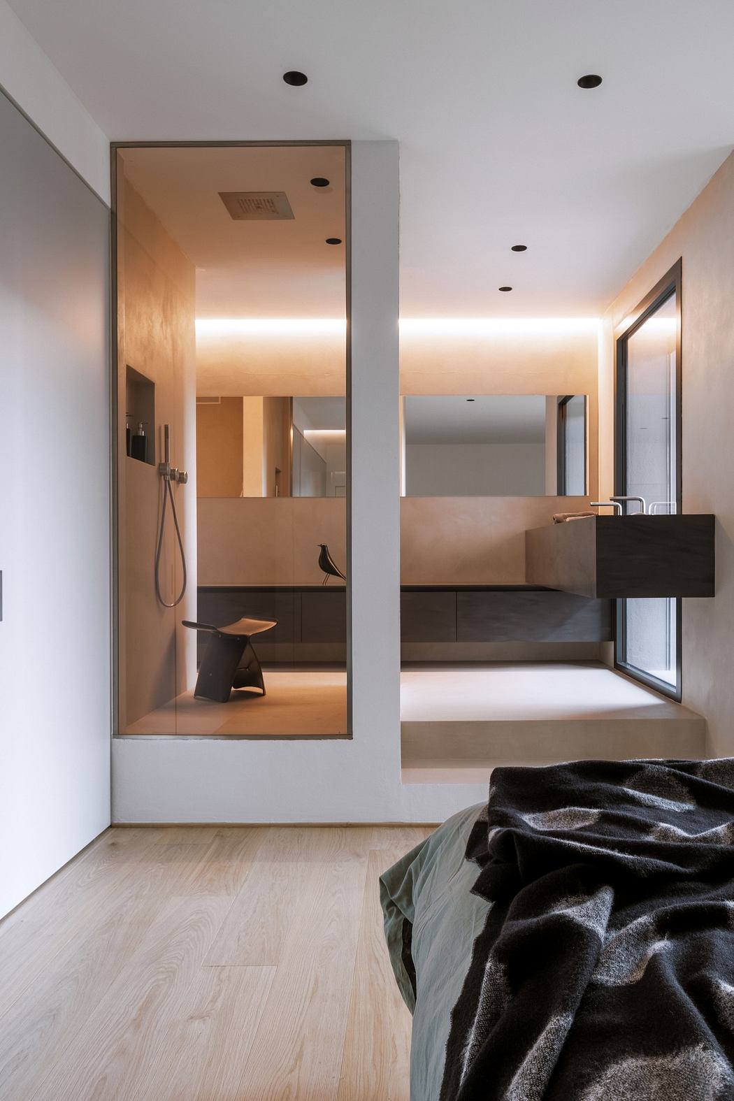 Modern minimalist bedroom with mirrored wardrobe and sleek built-in sink.
