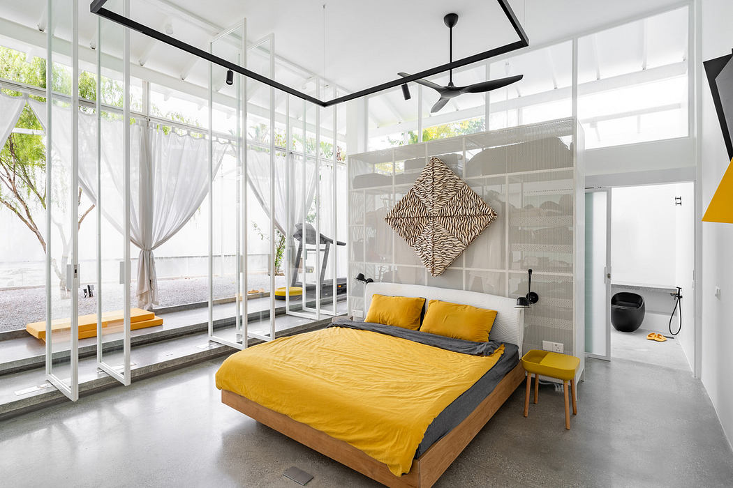 Modern bedroom with glass walls, a yellow bedspread, and minimalist decor.