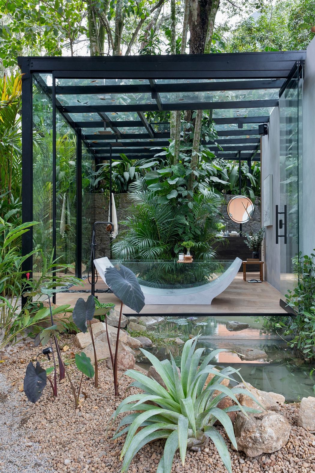 Modern glass greenhouse with lush interior plants and hammock.