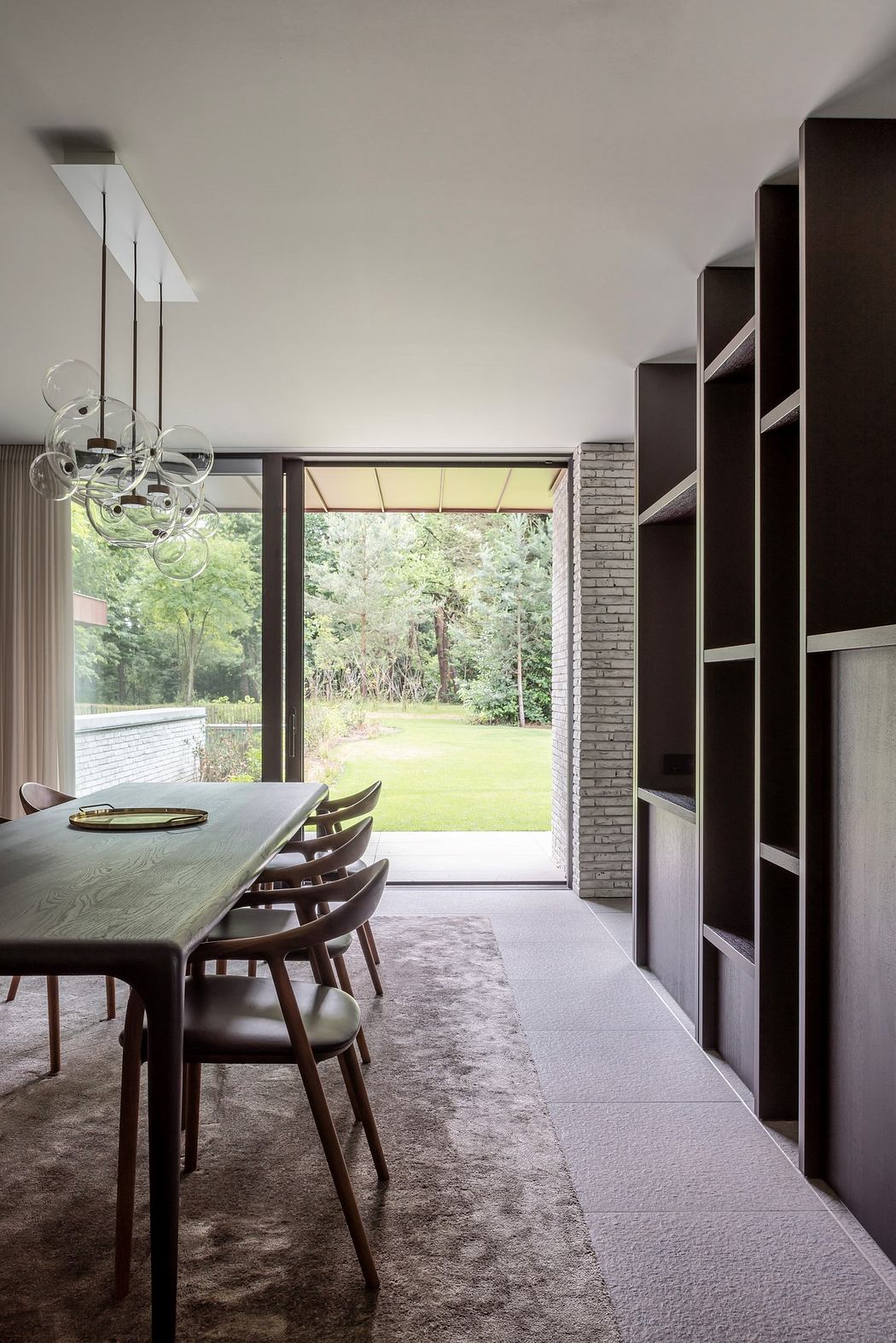 Modern dining room with large window overlooking a garden.