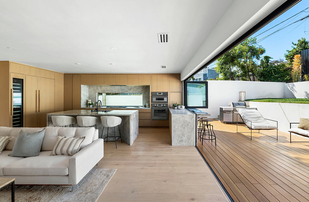 Modern open-plan living space with kitchen, living area, and outdoor deck.