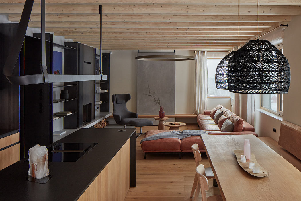 Modern kitchen with black cabinets and adjacent living area with wooden accents.