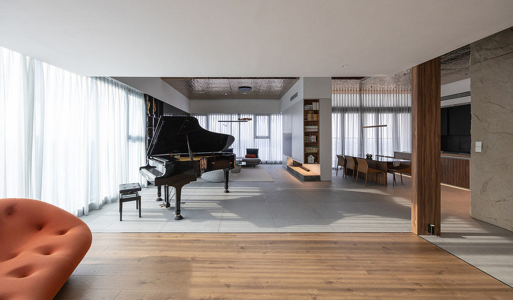 Modern open-plan living space with grand piano and wooden floors.