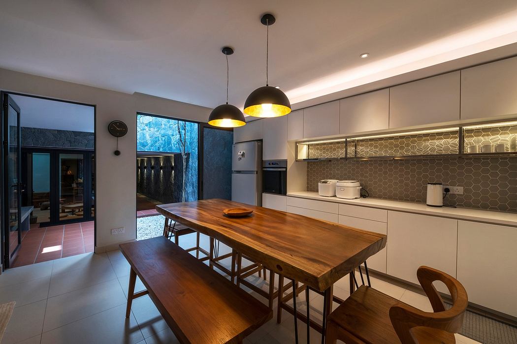 Modern kitchen interior with wooden table and pendant lights.
