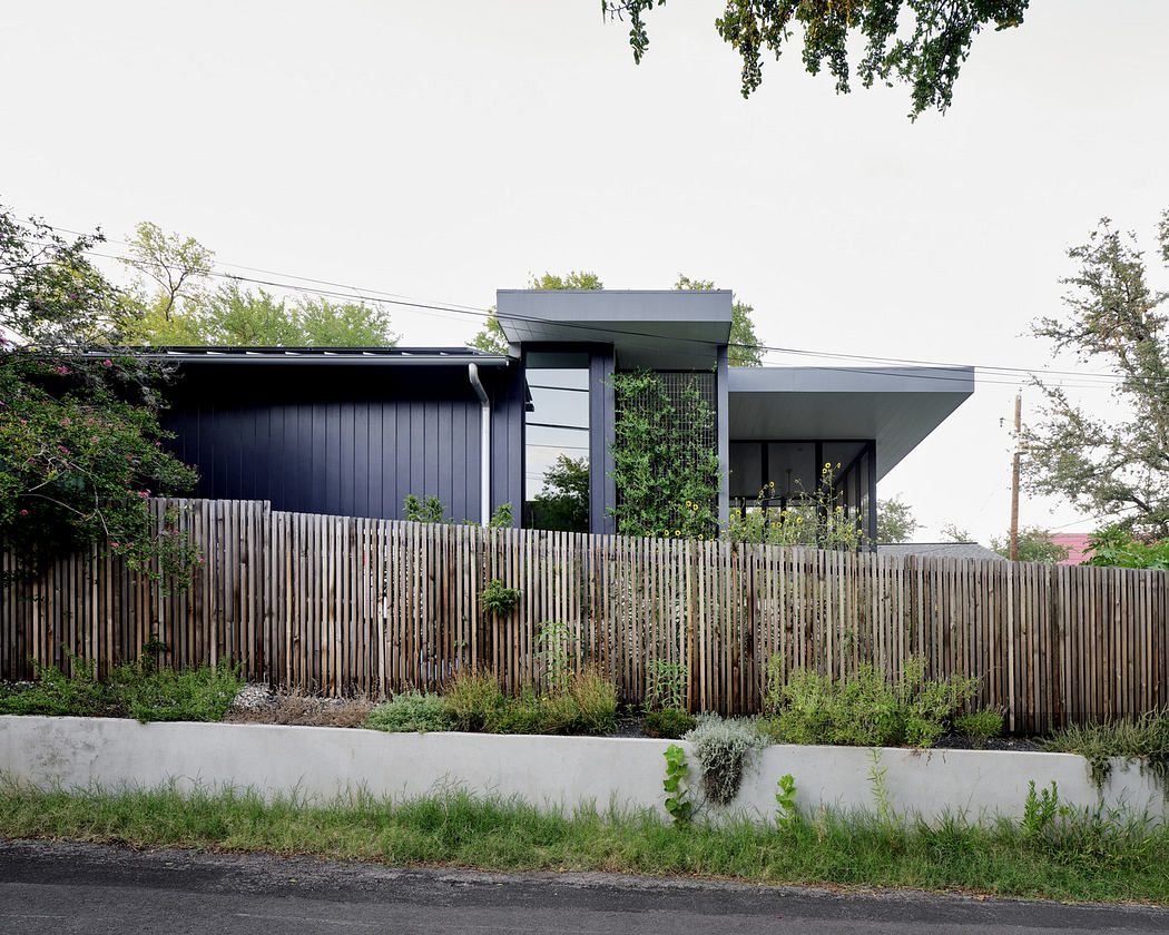 Modern house with a slanted roof and a wooden fence.