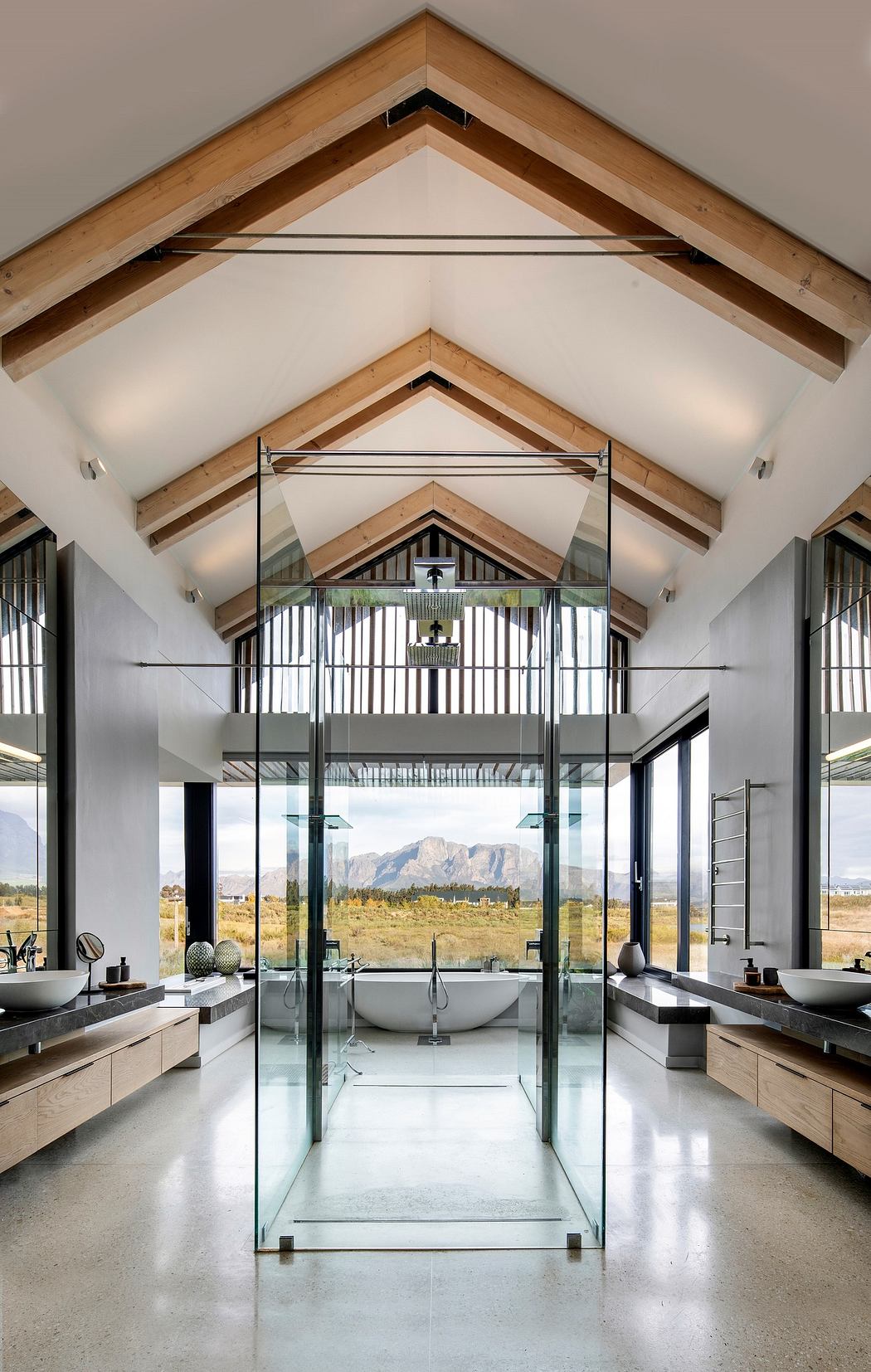 Modern interior with high ceilings, exposed beams, and floor-to-ceiling glass walls