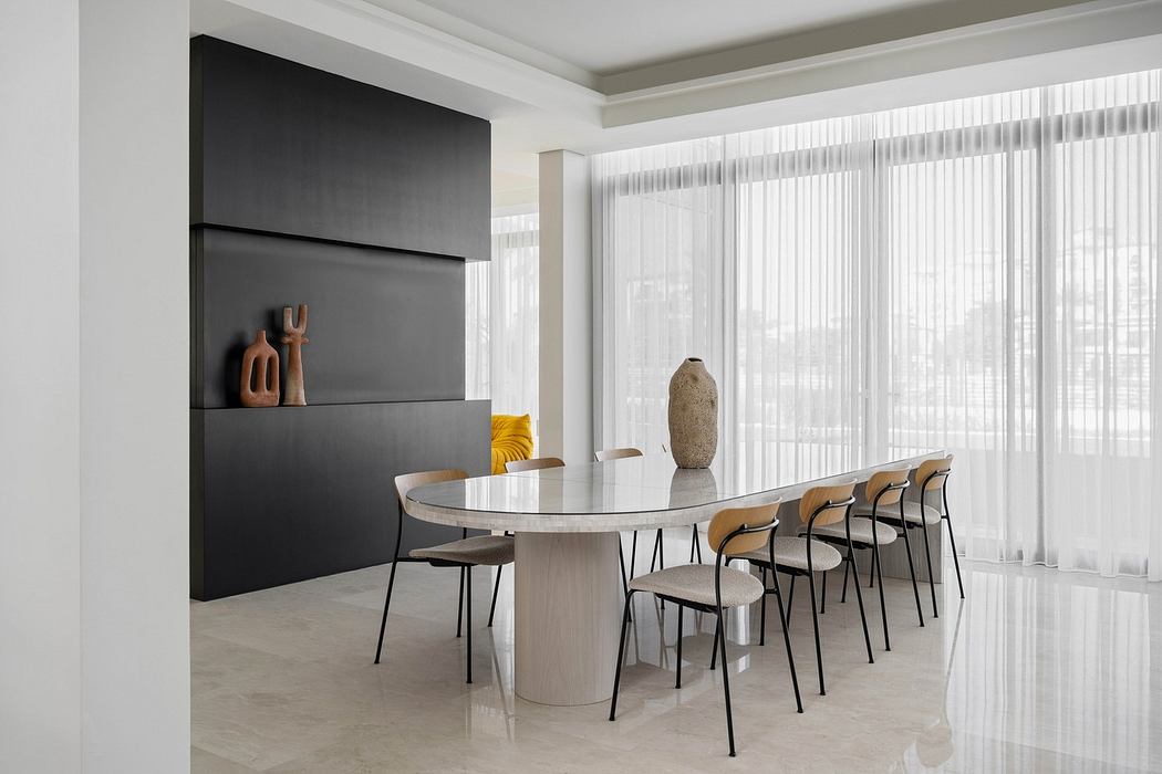 Modern dining room with a round table, chairs, and minimalist decor.