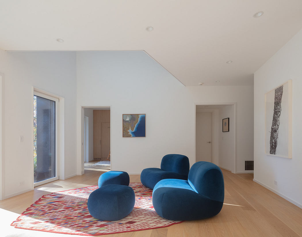 Modern living room with blue furniture and colorful rug.