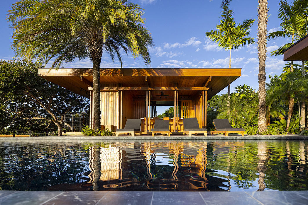 Modern tropical pavilion style house with pool and palm trees.