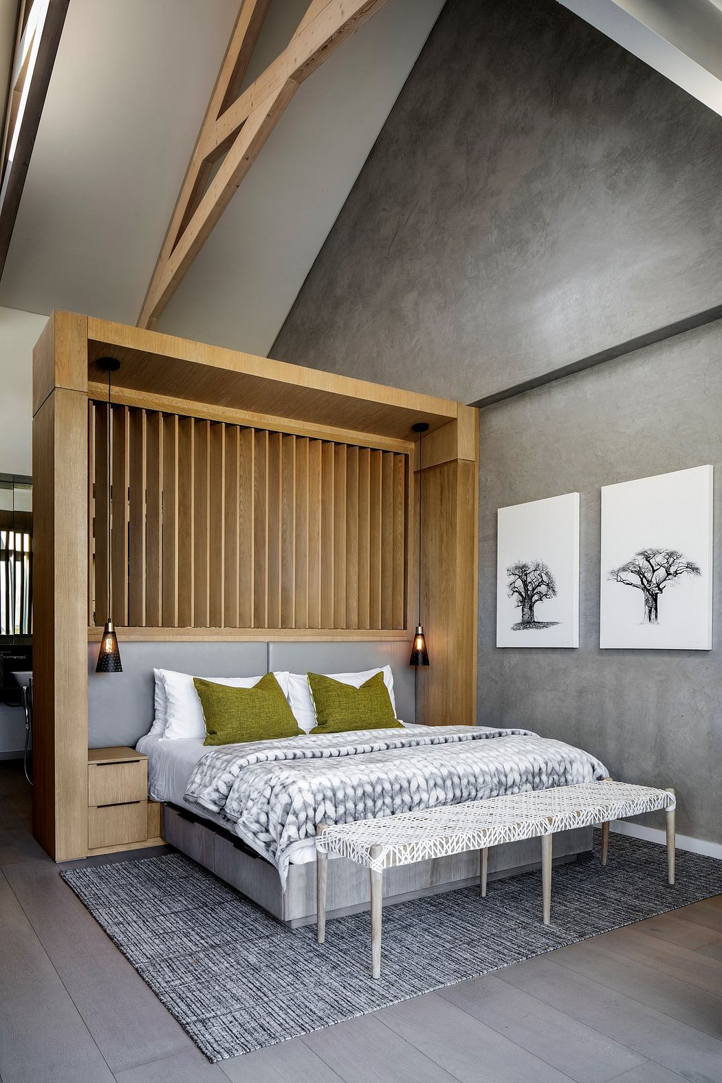Modern bedroom with wooden bed frame, grey walls, and art decor.