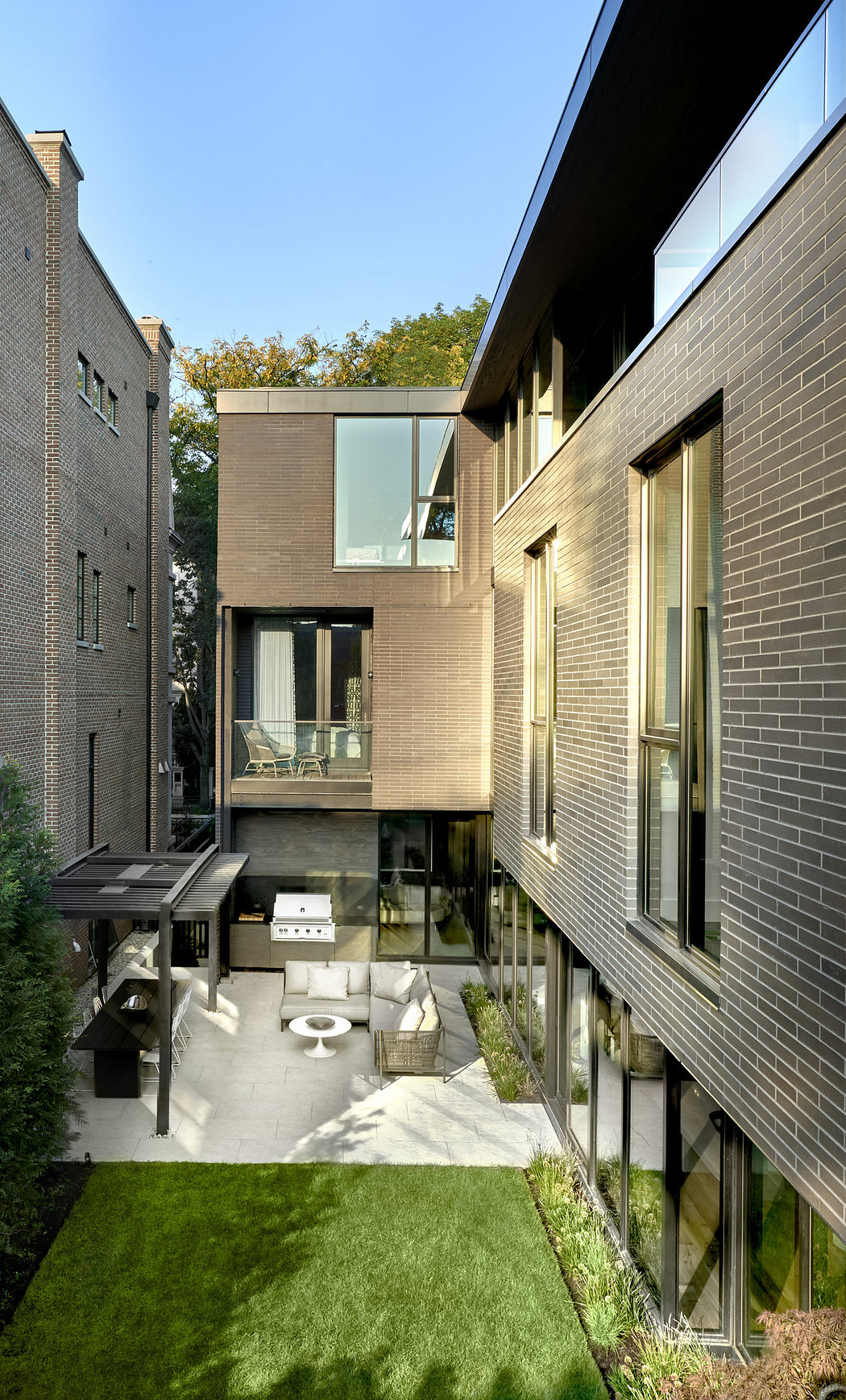 Modern urban backyard with a sleek two-story house and landscaped garden.