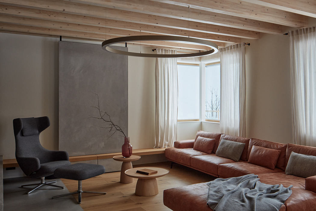 Modern living room with a large leather sofa, wooden beams, and a circular light