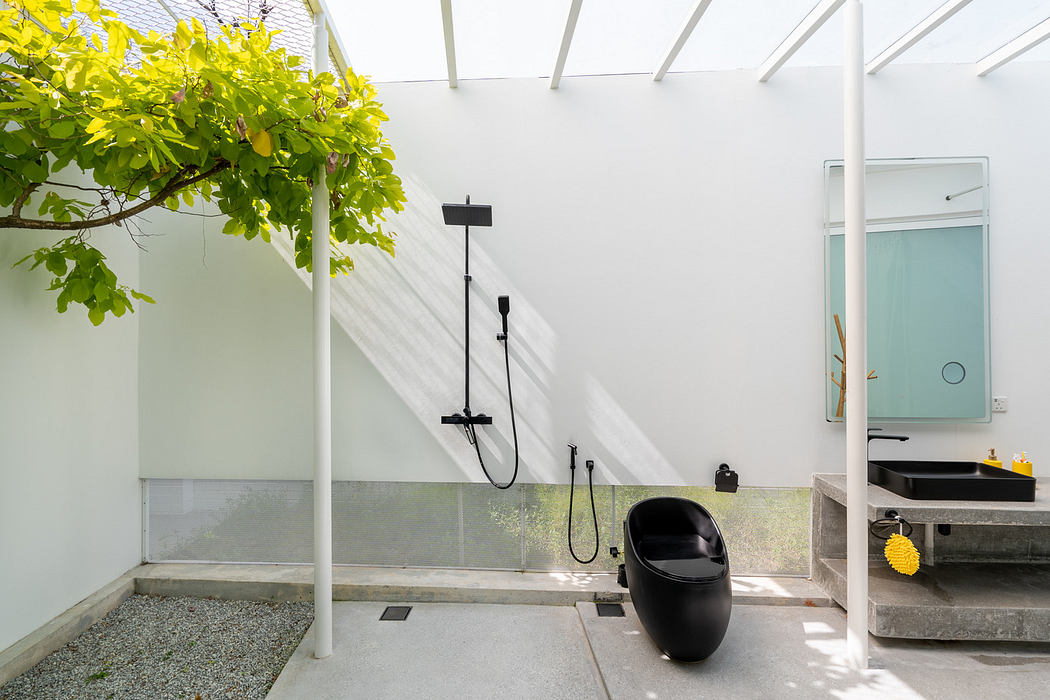 Minimalist outdoor bathroom with shower, black toilet, and greenery.