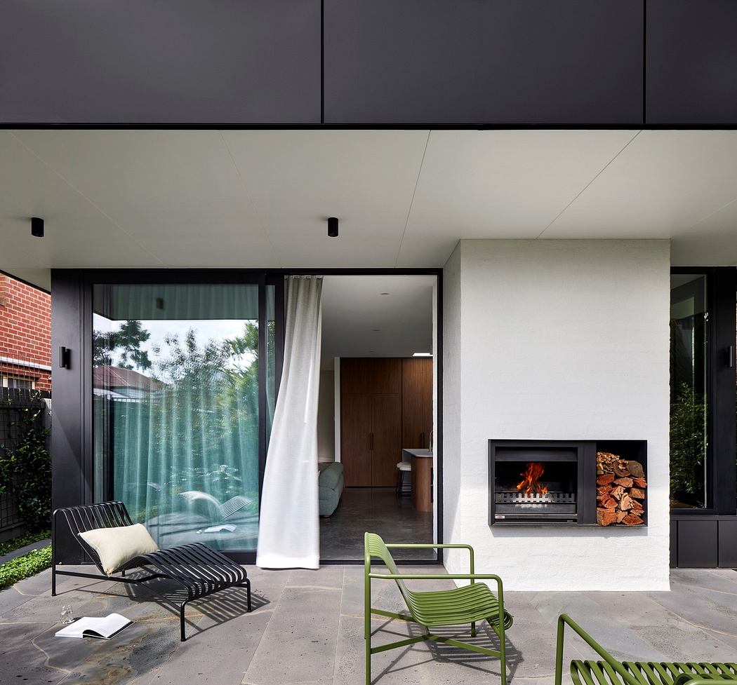 Modern patio with fireplace, lounge chairs, and floor-to-ceiling windows.