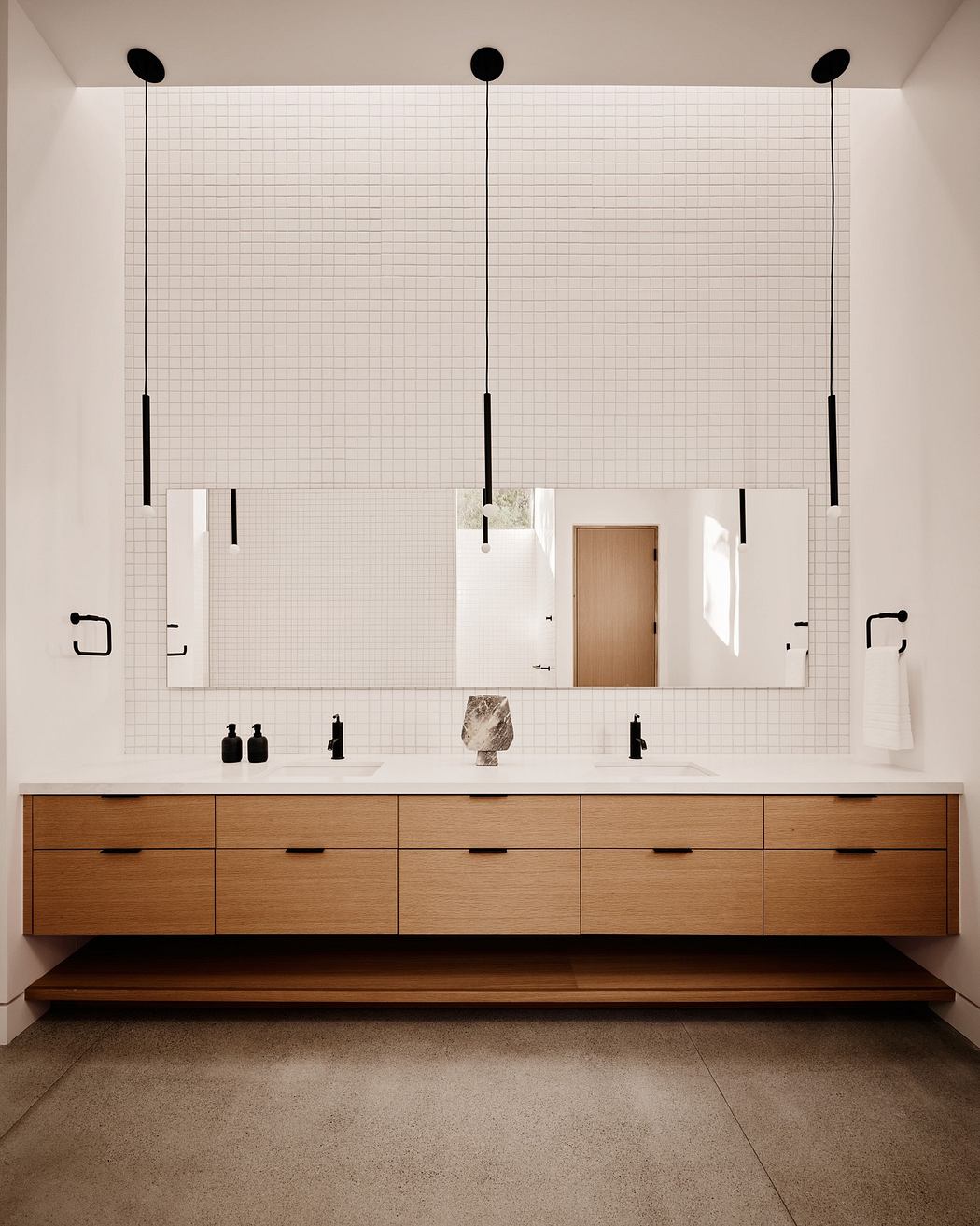 Modern bathroom with double vanity and wall-mounted faucets.