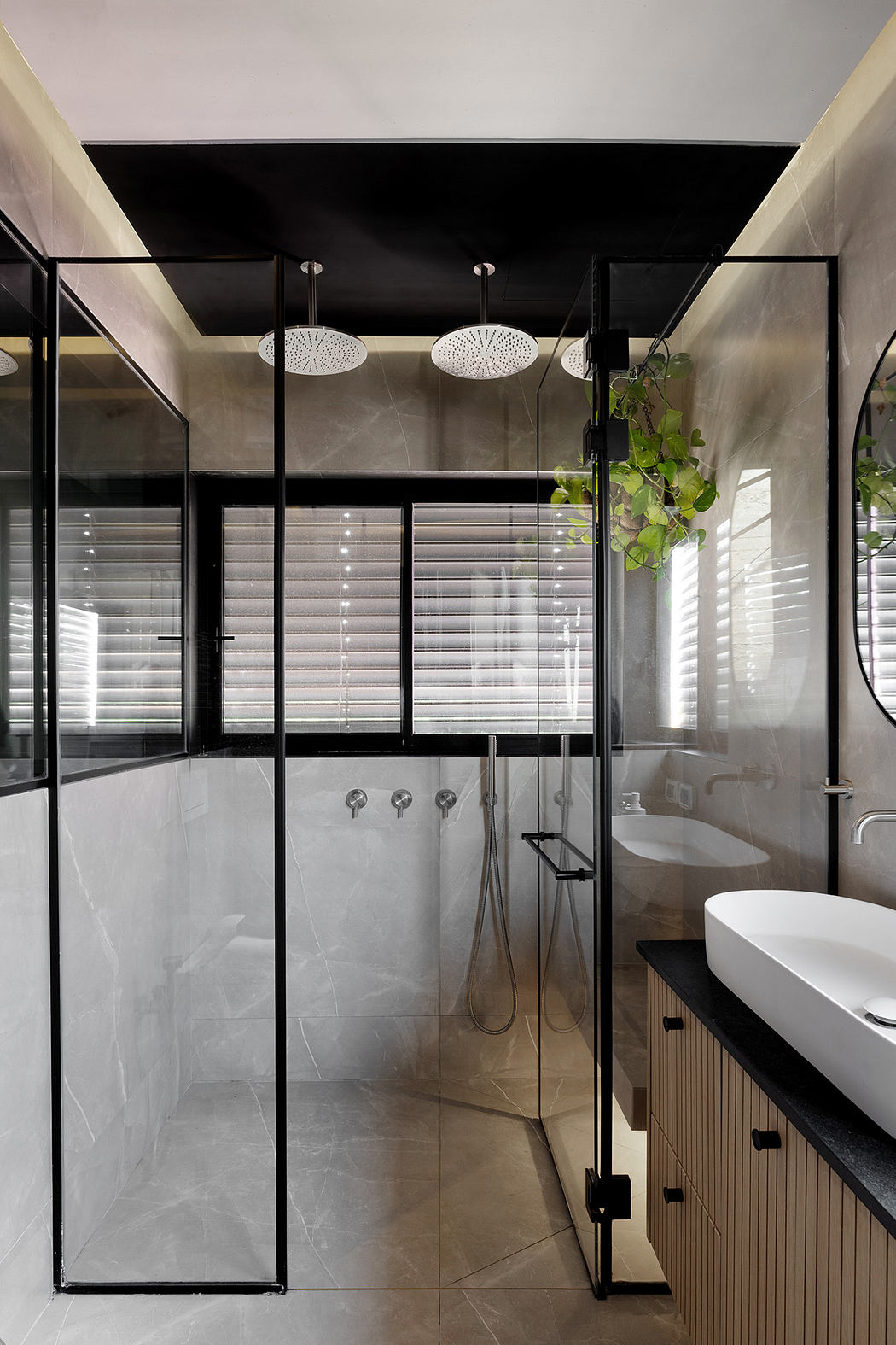 Modern bathroom with glass shower, wooden vanity, and hanging plants.