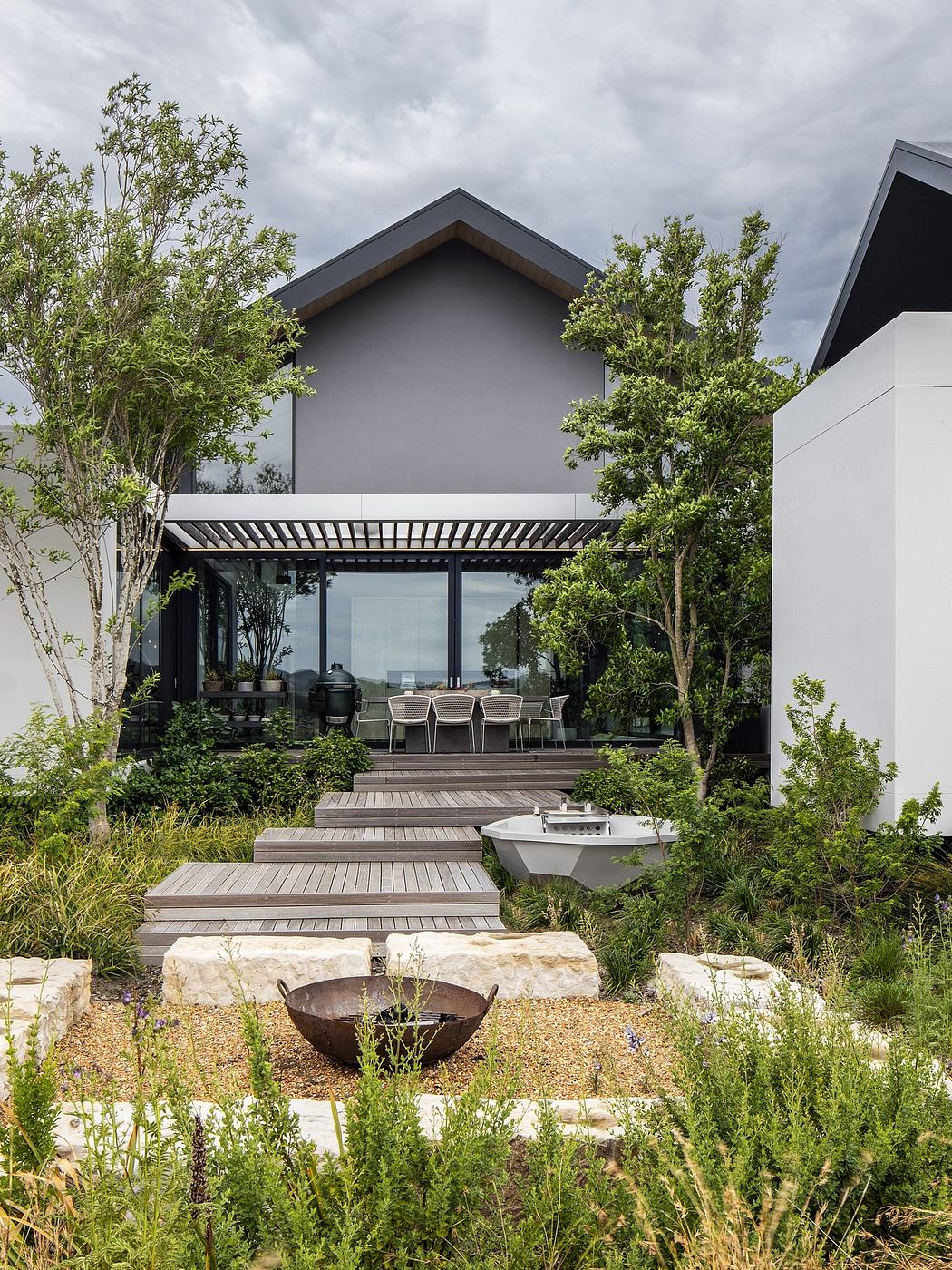 Modern home exterior with landscaped garden and wooden pathway.