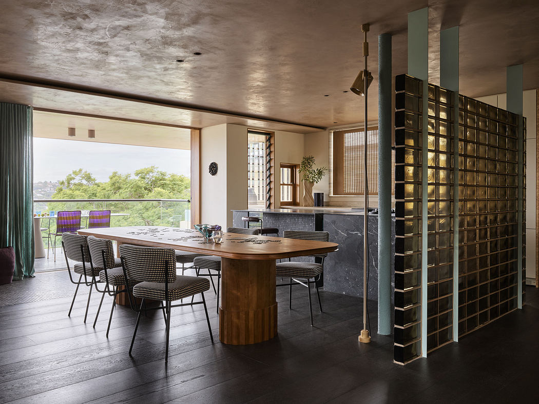 Modern dining room with wooden table, chairs, and glass partition, leading to a