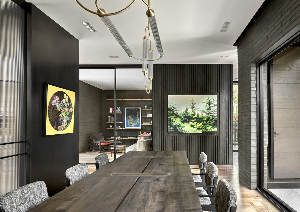Modern dining room with long table, art pieces, and elegant lighting.