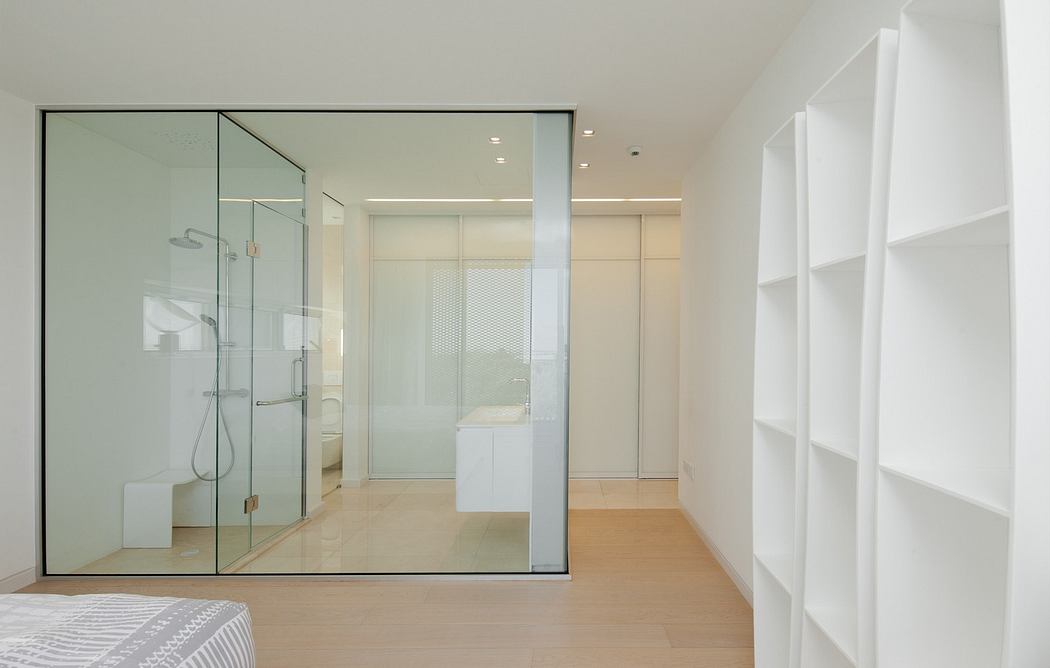 Modern minimalist bedroom with glass shower enclosure and white shelves.