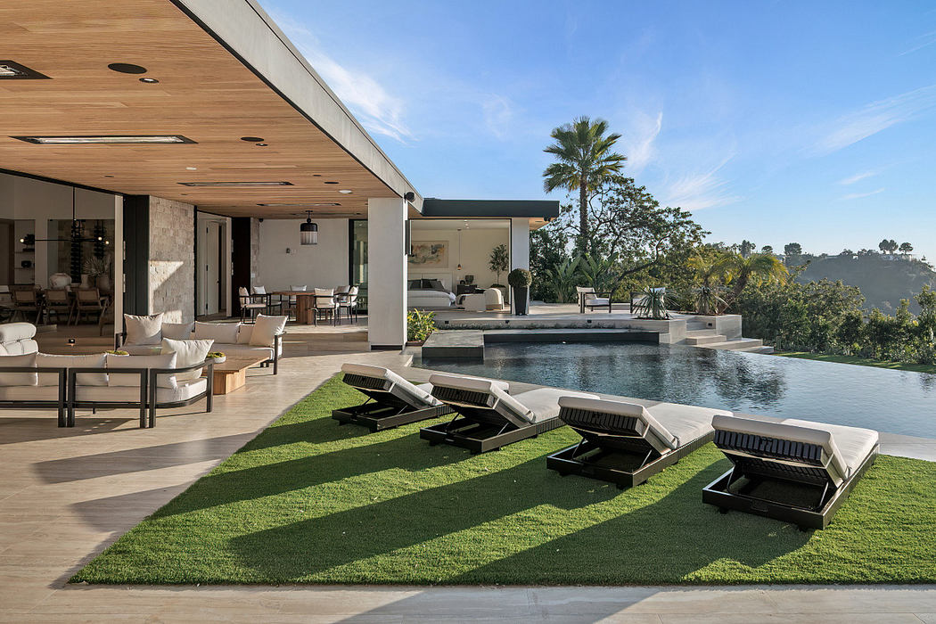 Modern outdoor patio with pool, lounge chairs, and open living space.