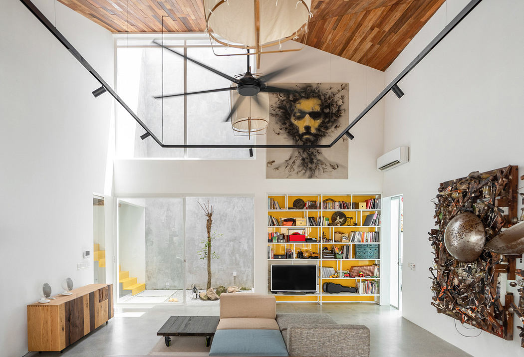 Modern living room with high ceiling, bookshelf, and eclectic art.
