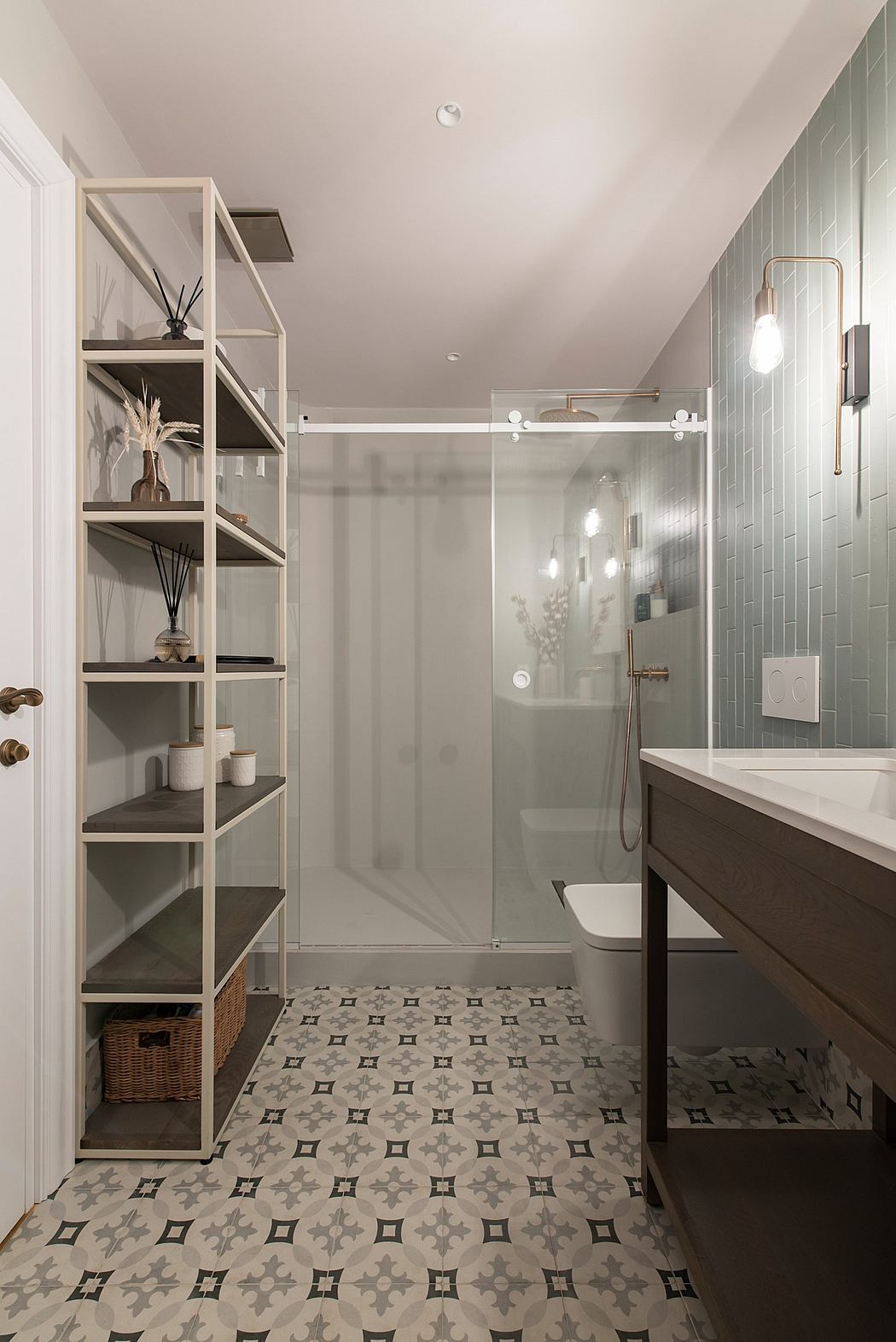 Modern bathroom with patterned floor tiles, glass shower, and shelving unit.