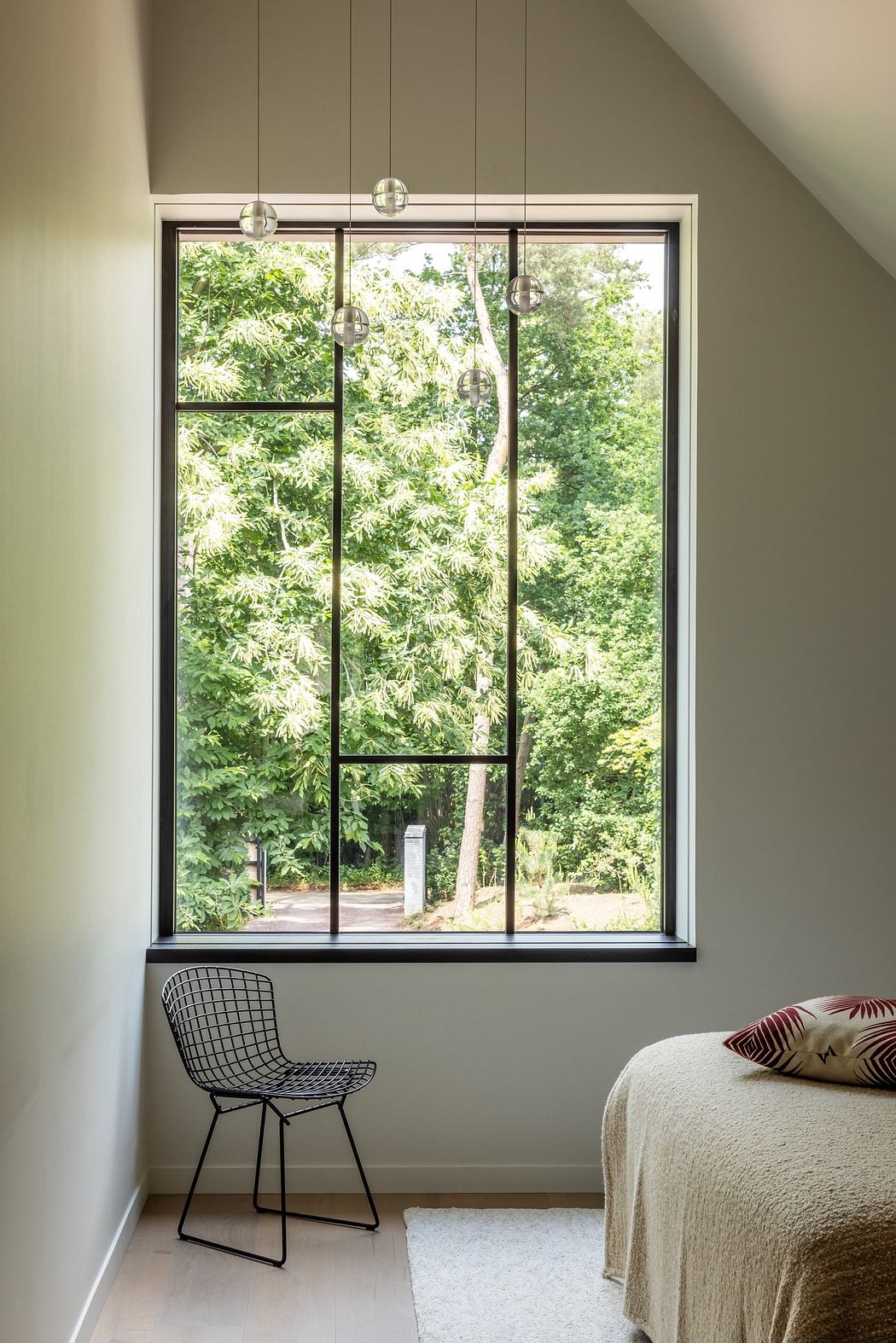 Minimalist room with large window, pendant lights, and a single chair.