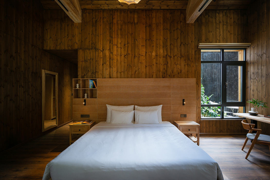 Wood-paneled bedroom with minimalistic design and large window.