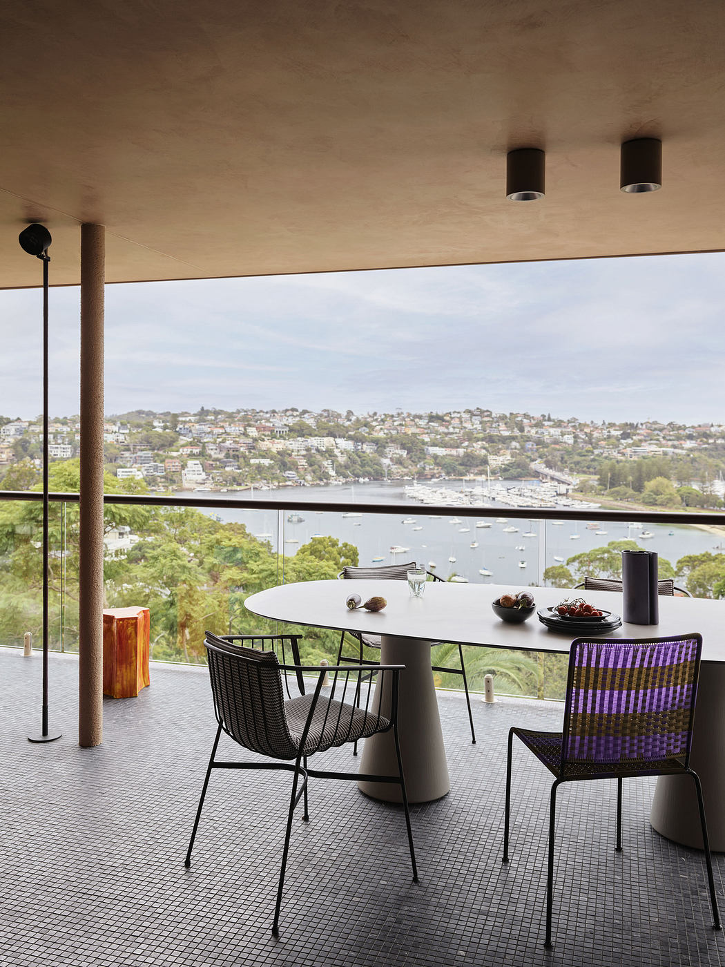 Modern balcony with stylish furniture and scenic river view.
