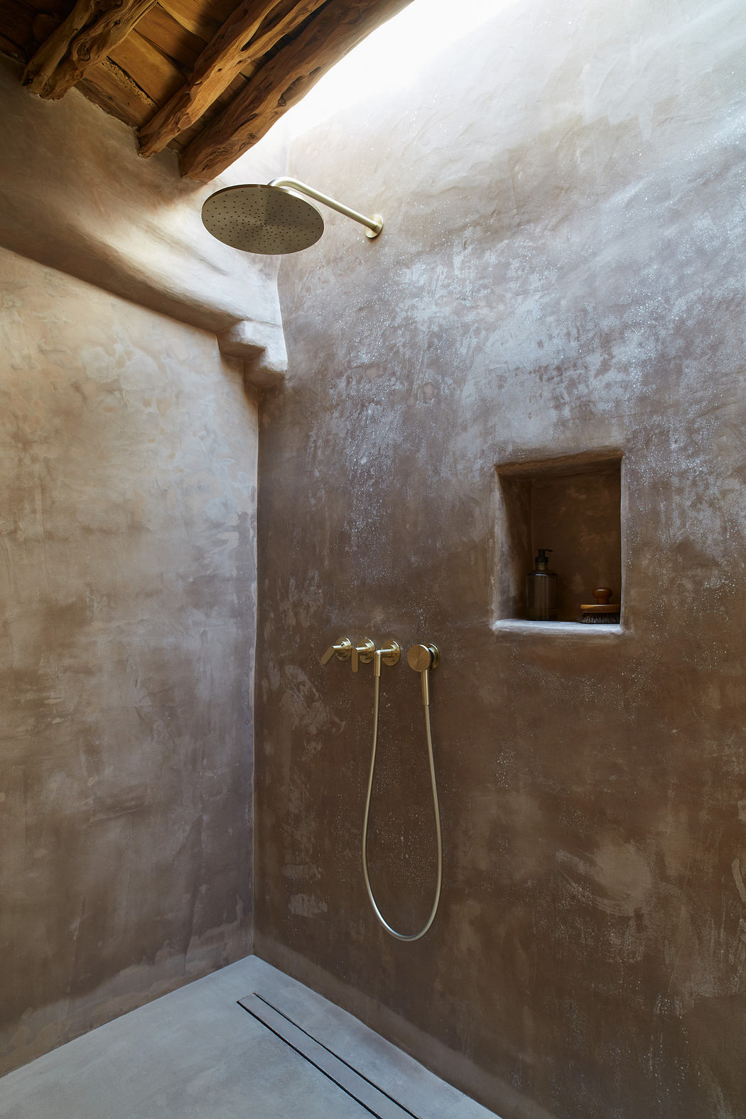 Modern rustic shower with textured walls and wood ceiling.