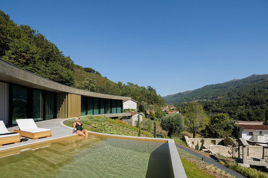Modern hillside house with infinity pool and forest view.