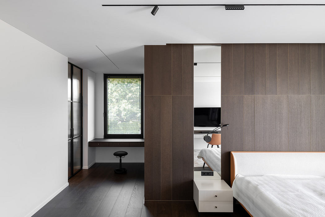 Modern minimalist bedroom with sleek wooden partition and window view.